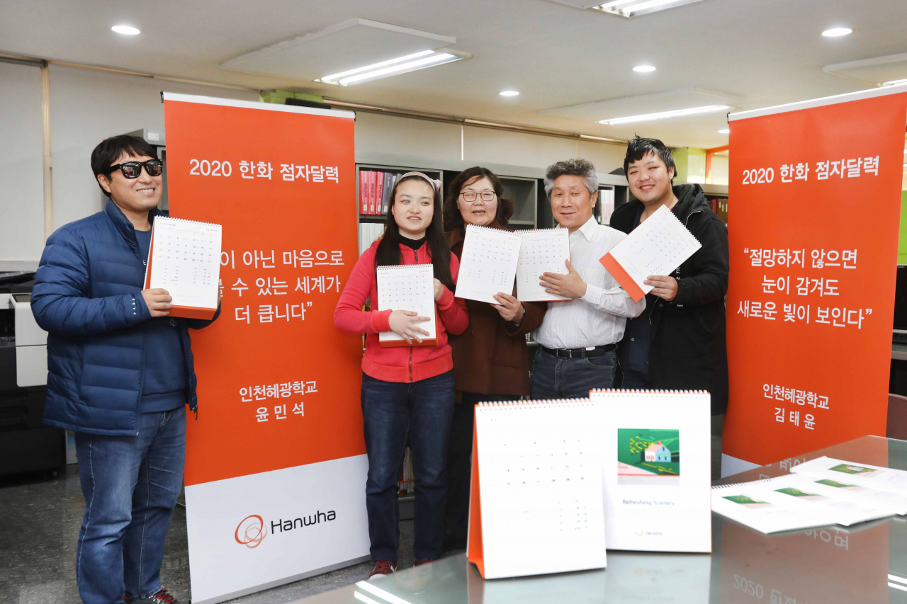 한화그룹이 시각장애인들을 위한 점자달력 4만부를 제작해 무료로 배포한다. 2020년 탁상용 점자달력에는 시각장애인들이 세상에 전하고 싶은 메시지를 글과 점자로 표현했다. 인천광역시에 위치한 혜광학교에서 이료재활과정을 이수중인 시각장애인들이 내년도 점자달력을 읽고 있다. [한화그룹 제공]