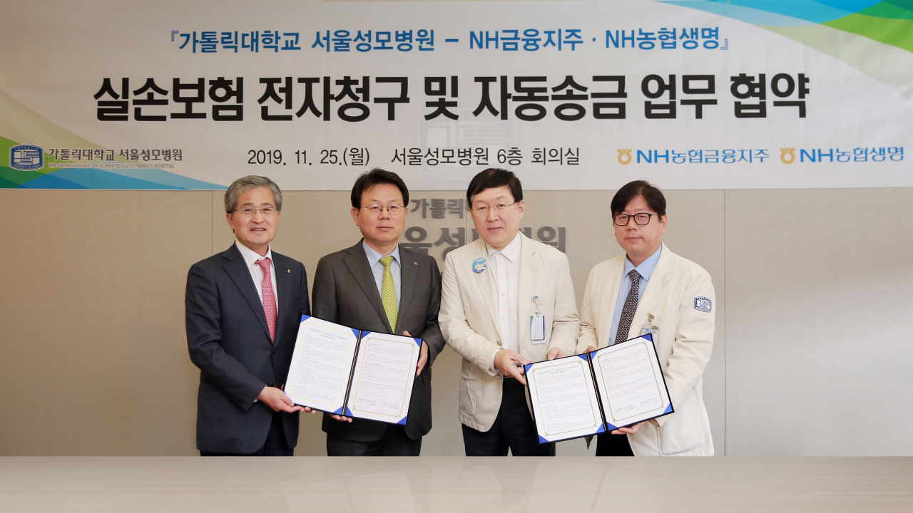 '실손보험 전자청구 및 자동송금 업무협약' 체결식이 25일 서울 서초구 소재 서울성모병원 회의실에서 열렸다. 사진 왼쪽부터 홍재은 NH농협생명 대표이사, 김광수 농협금융 회장, 김용식 서울성모병원장, 이지열 서울성모병원 스마트병원장.