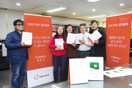 인천광역시에 위치한 혜광학교에서 이료재활과정을 이수중인 시각장애인들이 한화그룹이 제작한 내년도 점자달력을 읽고 있다. [한화그룹 제공]