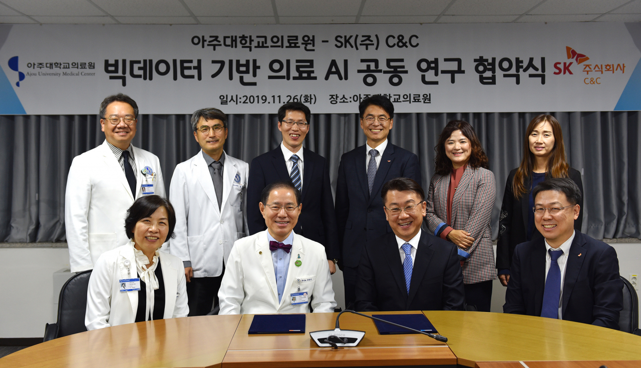26dlf 아주대학교의료원에서 SK(주) C&C 윤동준 Healthcare 그룹장(아래 왼쪽에서 3번째)과 유희석 아주대학교의료원장(아래 왼쪽에서 2번째) 등 행사 관계자들이 ‘빅데이터 기반 의료AI 공동 연구 협약(MOU)’ 체결 후 기념촬영을 하는 모습 [SK C&C 제공]