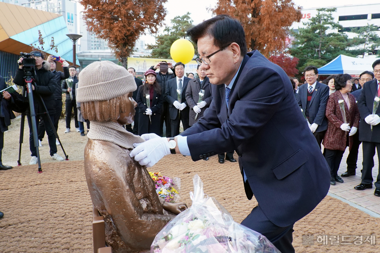 27일 동대문구 용두공원에서 열린 평화의 소녀상 제막식에서 유덕열 동대문 구청장이 소녀상에 목도리를 둘러 주고 있다. [동대문구 제공]