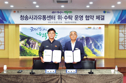 백남진(오른쪽) 영농법인송원APC 대표가 지난 8월 경북 청송군청에서 열린 청송사과유통센터 위·수탁 운영협약식에서 기념촬영하고 있다. [영농법인송원APC]