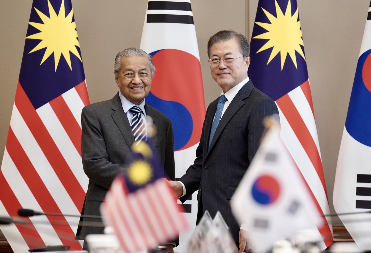 President Moon Jae-in and Malaysian Prime Minister Mahathir bin Mohamad pose for a photograph before the summit meeting at the presidential office in Seoul on Thursday. Yonhap