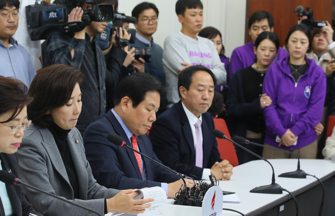 자유한국당 나경원 원내대표가 29일 국회에서 민식·태호·해인 부모들이 지켜보는 가운데 필리버스터 신청과 관련해 기자회견하고 있다. [연합]