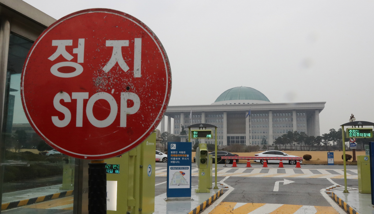 국회 출입문 교통표지판 너머로 국회 본관이 보인다. [연합뉴스]