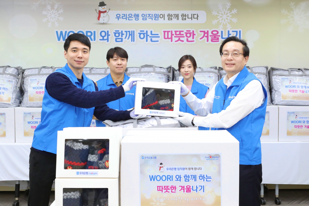 우리금융은 지난달 25일 서울 중구 우리은행 본점에서 겨울용품 포장 봉사활동을 진행하고 아동복지관에 전달했다. 손태승(오른쪽 첫번째) 우리금융 회장이 임직원들과 기념촬영을 하고 있다. [우리금융 제공]