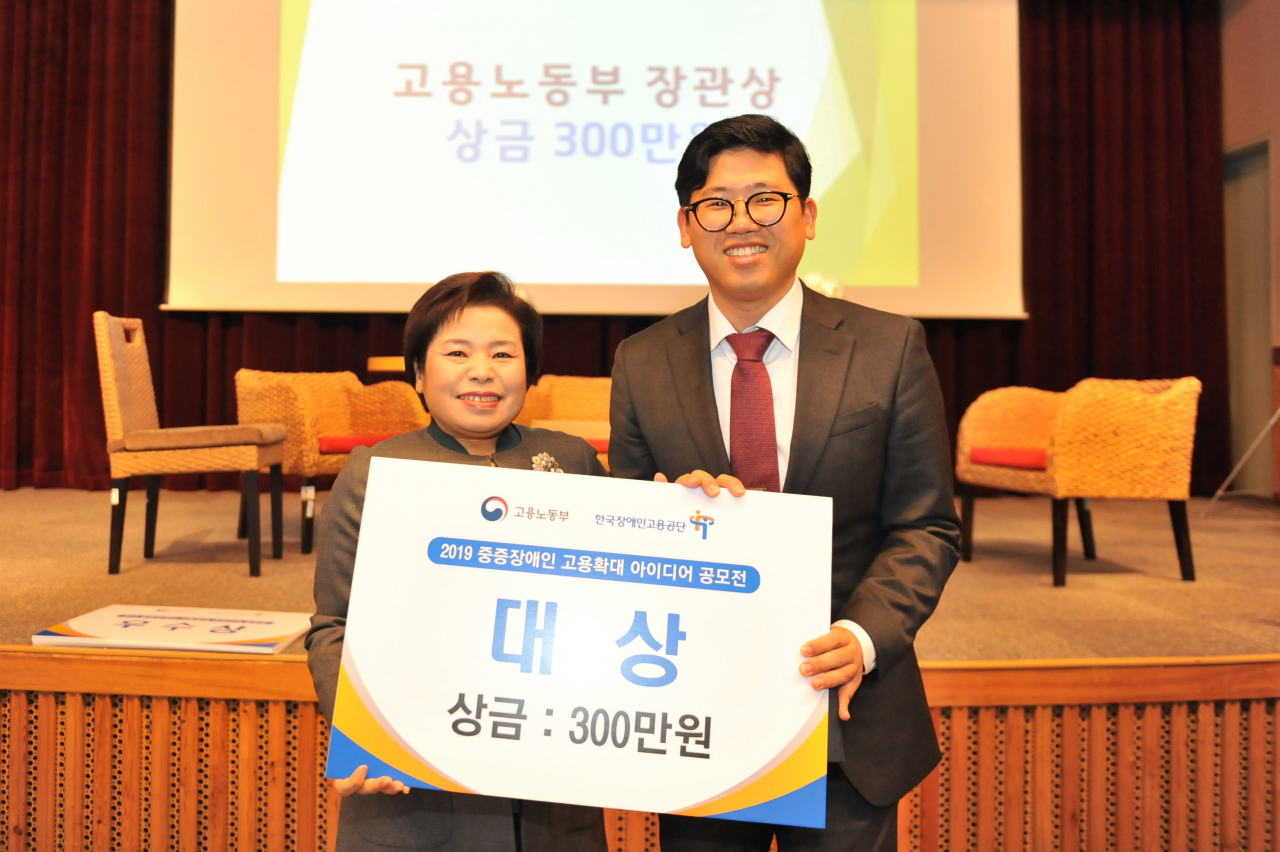 조종란 한국장애인고용공단 이사장(왼쪽)이 공모전에서 대상을 받은 국립공원공단 국립공원연구원 관계자에게 시상한 후 기념사진을 찍고 있다. [한국장애인고용공단 제공]
