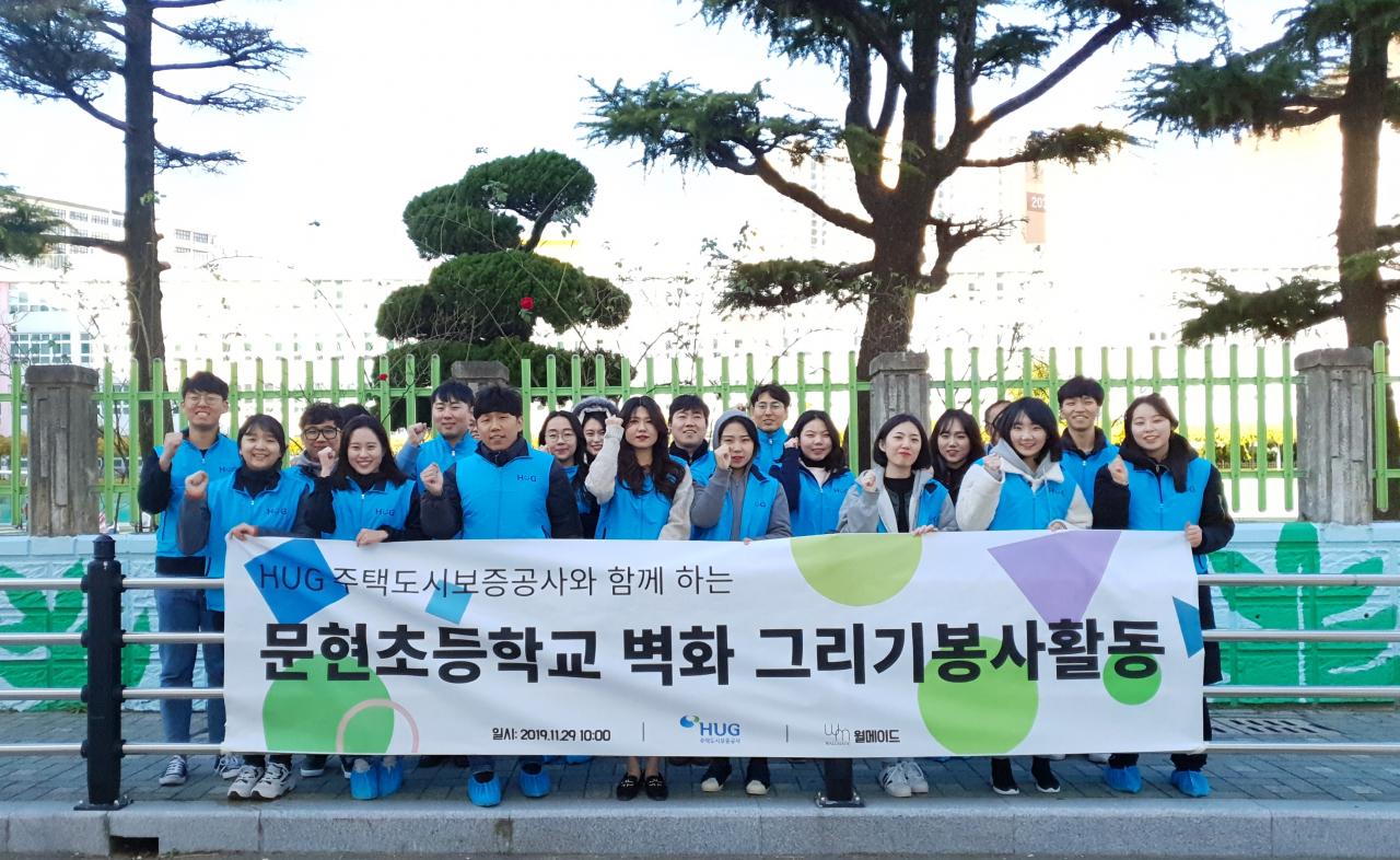 지난달 29일 부산 남구 소재 한 초등학교에서 벽화그리기 봉사활동에 참여한 HUG 임직원 및 대학생 봉사단이 기념촬영을 하고 있다. [사진-HUG제공]