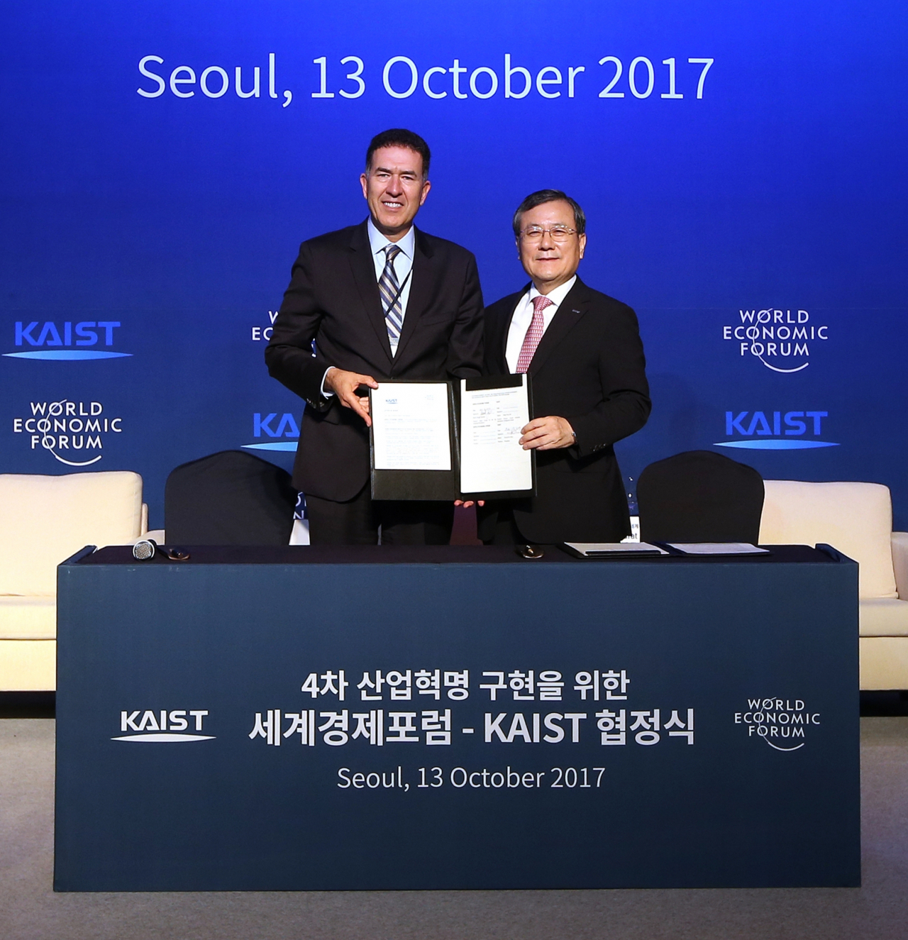 2017년 10월 신성철(오른쪽) KAIST 총장과 무라트 손메즈 WEF 4차산업혁명센터장이 업무협정을 체결하고 있다.[KAIST 제공]