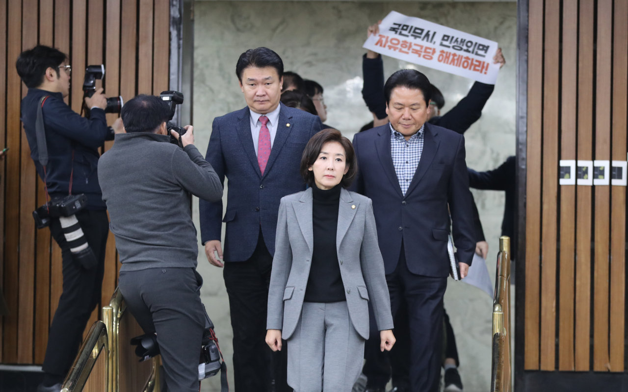 나경원 자유한국당 원내대표가 3일 오전 서울 여의도 국회에서 열린 원내 대책회의에 참석하기 위해 이동하는 가운데 한 남성이 자유한국당을 규탄하는 손팻말을 들고 있다. [연합]
