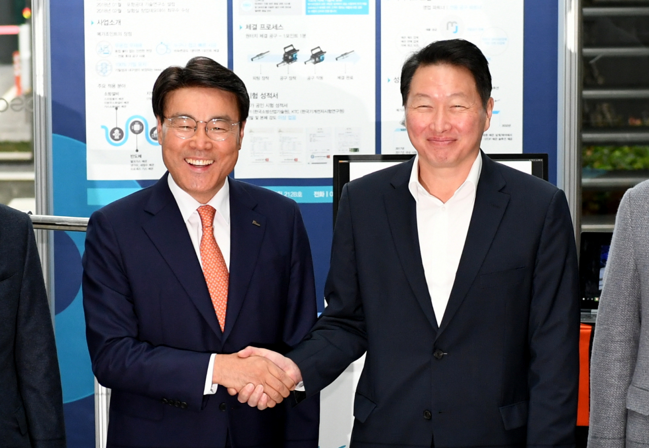 포스코가 3일 서울 대치동 포스코센터에서 ‘2019 기업시민 포스코 성과 공유의 장’을 개최한 가운데 행사에 참석한 최정우 포스코 회장(좌)과 최태원 SK그룹 회장(우)이 손을 잡으며 활짝 웃고 있다. [POSCO 제공]