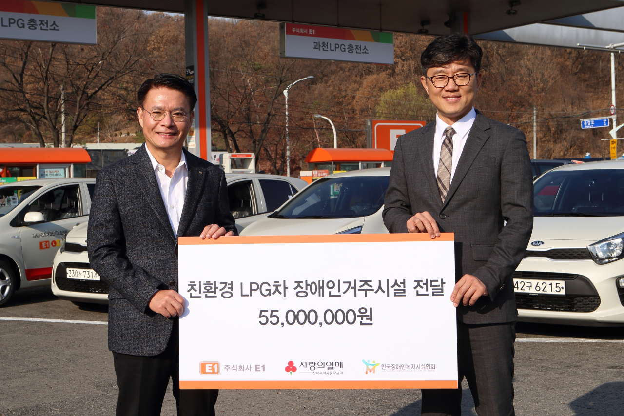E1은 4일 과천LPG충전소에서 장애인 거주시설 4개소에 LPG차를 전달했다. 왼쪽부터 강정석 E1 지원본부장, 정석왕 한국장애인복지시설협회장. [E1 제공]