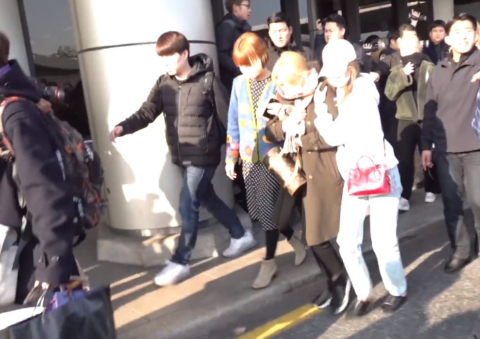 트와이스 멤버 지효과 8일 입국 도중 넘어진 팬에 걸려 넘어지면서 다리를 다쳐 멤버들의 부축을 받으며 이동하는 모습. [유튜브 캡처]