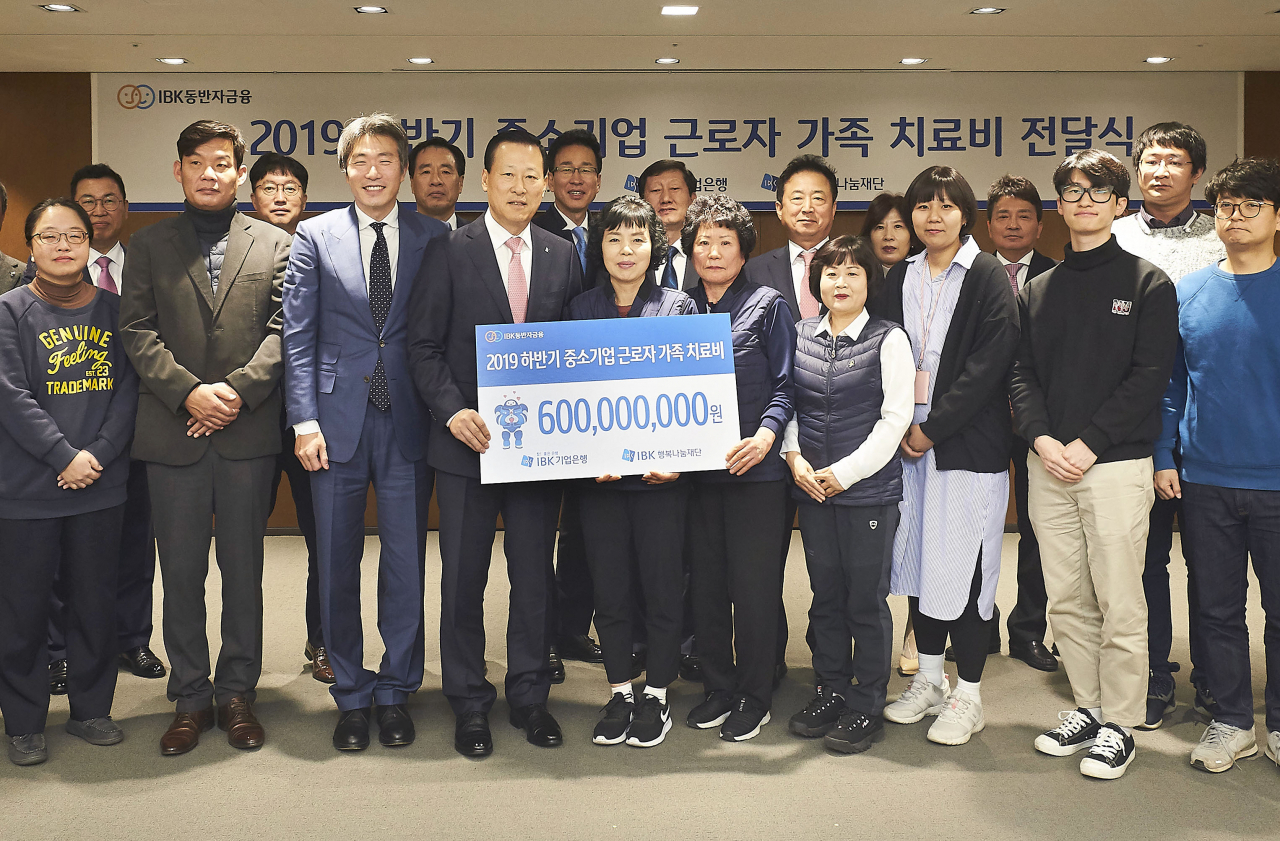 9일 을지로 기업은행 본점에서 김도진 은행장(앞줄 왼쪽 네 번째)과 중소기업 근로자 가족들이 치료비 전달식을 마치고 기념촬영을 하고 있다. [사진=IBK기업은행]
