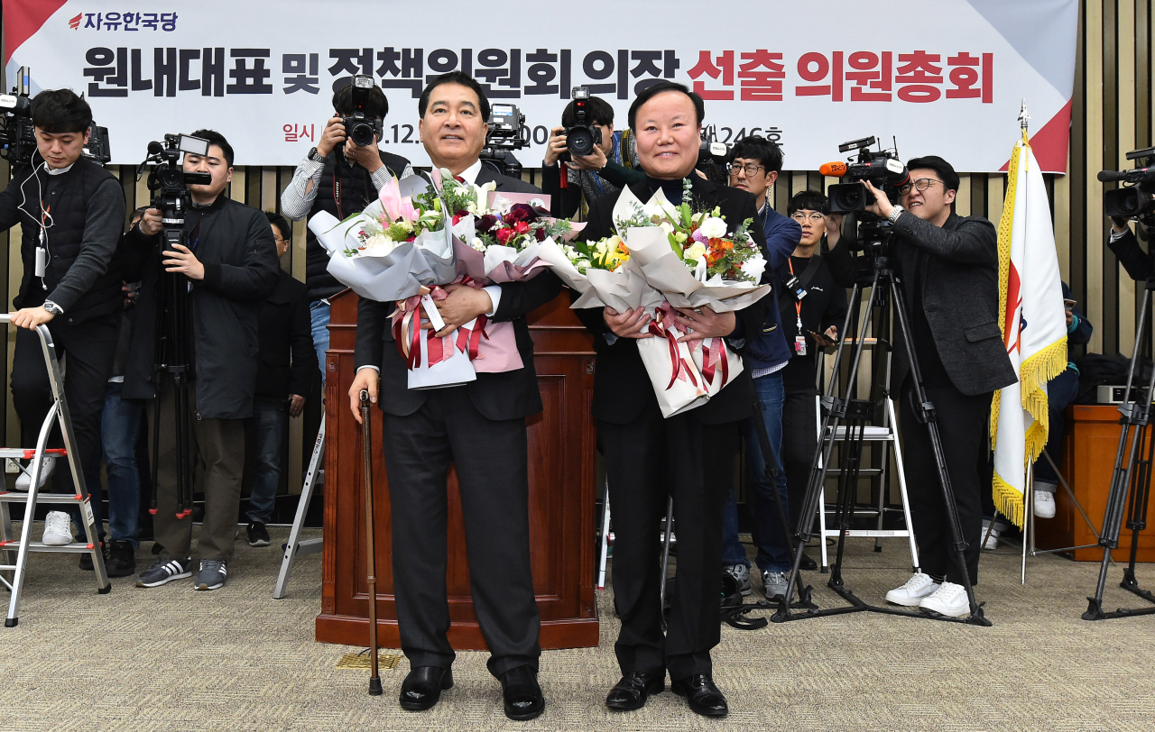 자유한국당 원내대표에 선출된 심재철 의원(왼쪽)과 신임 김재원 정책위의장이 9일 국회에서 열린 의원총회에서 축하 꽃다발을 받고 기뻐하고 있다. [연합]