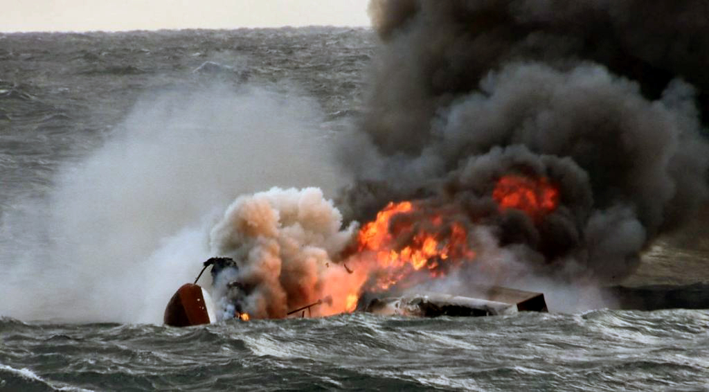 A capsized boat on fire is submerged in the waters near Jeju Island on Nov. 19. (Jeju Regional Coast Guard)