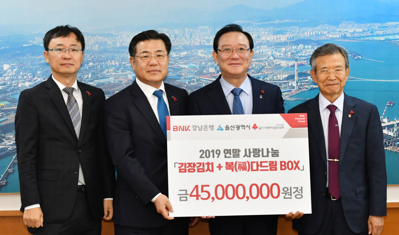 BNK경남은행 김갑수 상무(사진 왼쪽 두번째)가 울산시 송철호 시장(사진 왼쪽 세번째)과 울산사회복지공동모금회 한시준 회장에게 ‘김장 김치·복(福)다드림박스 기탁 증서’를 전달하고 있다.