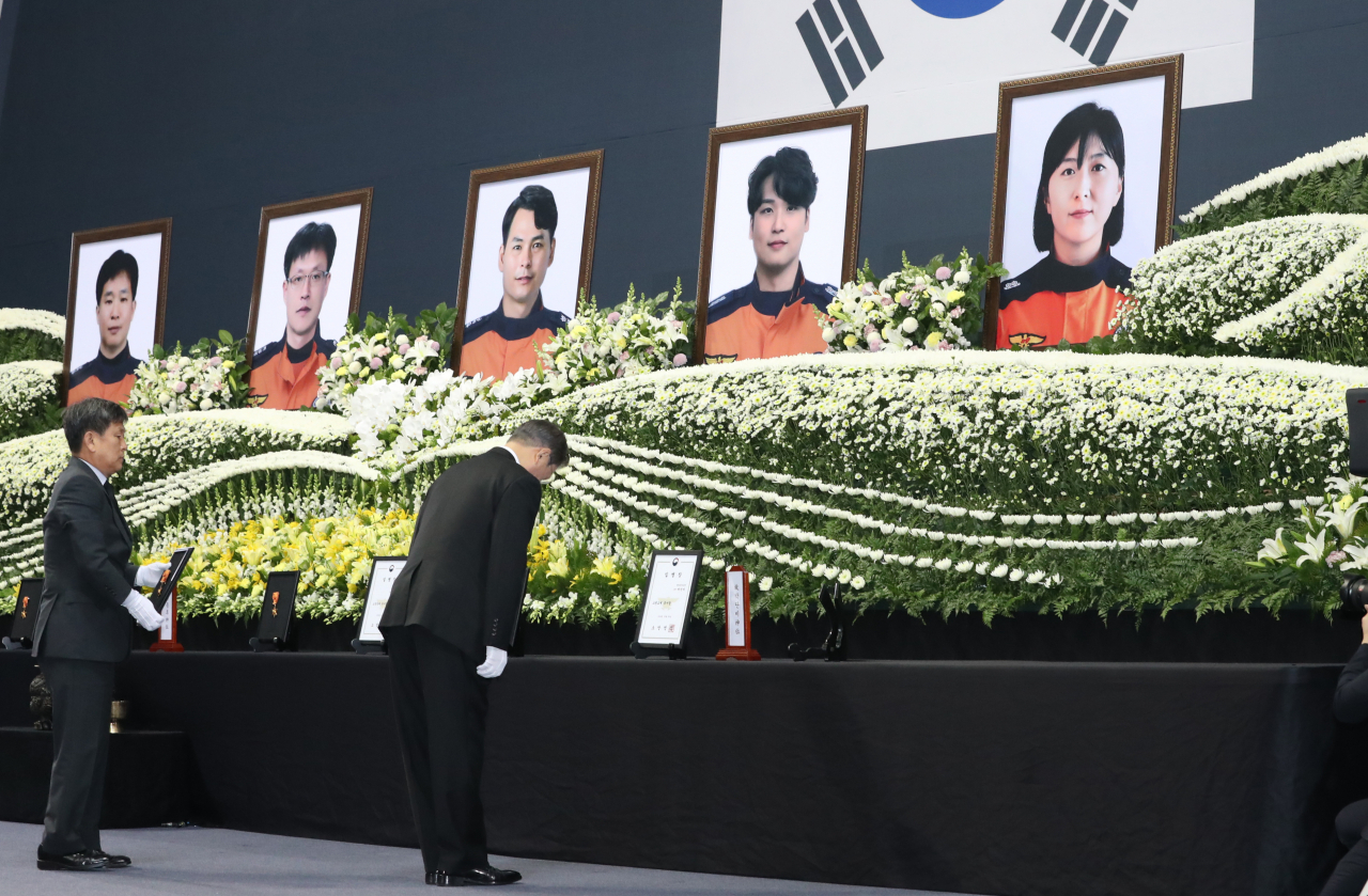 문재인 대통령이 10일 오전 대구 달서구 계명대 체육관에서 열린 독도 해역 헬기 추락사고 순직 소방항공대원 합동영결식에서 고인에 대해 훈장을 추서하고 있다. [연합]