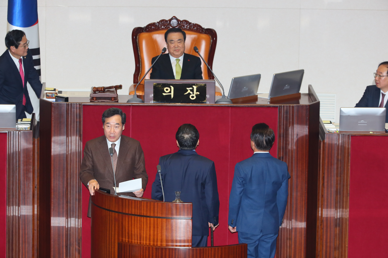 이낙연 국무총리가 10일 국회 본회의에서 자유한국당 의원들이 문희상 의장에게 예산안 가결에 항의하는 동안 정부측 인사를 하고 있다. ［연합］