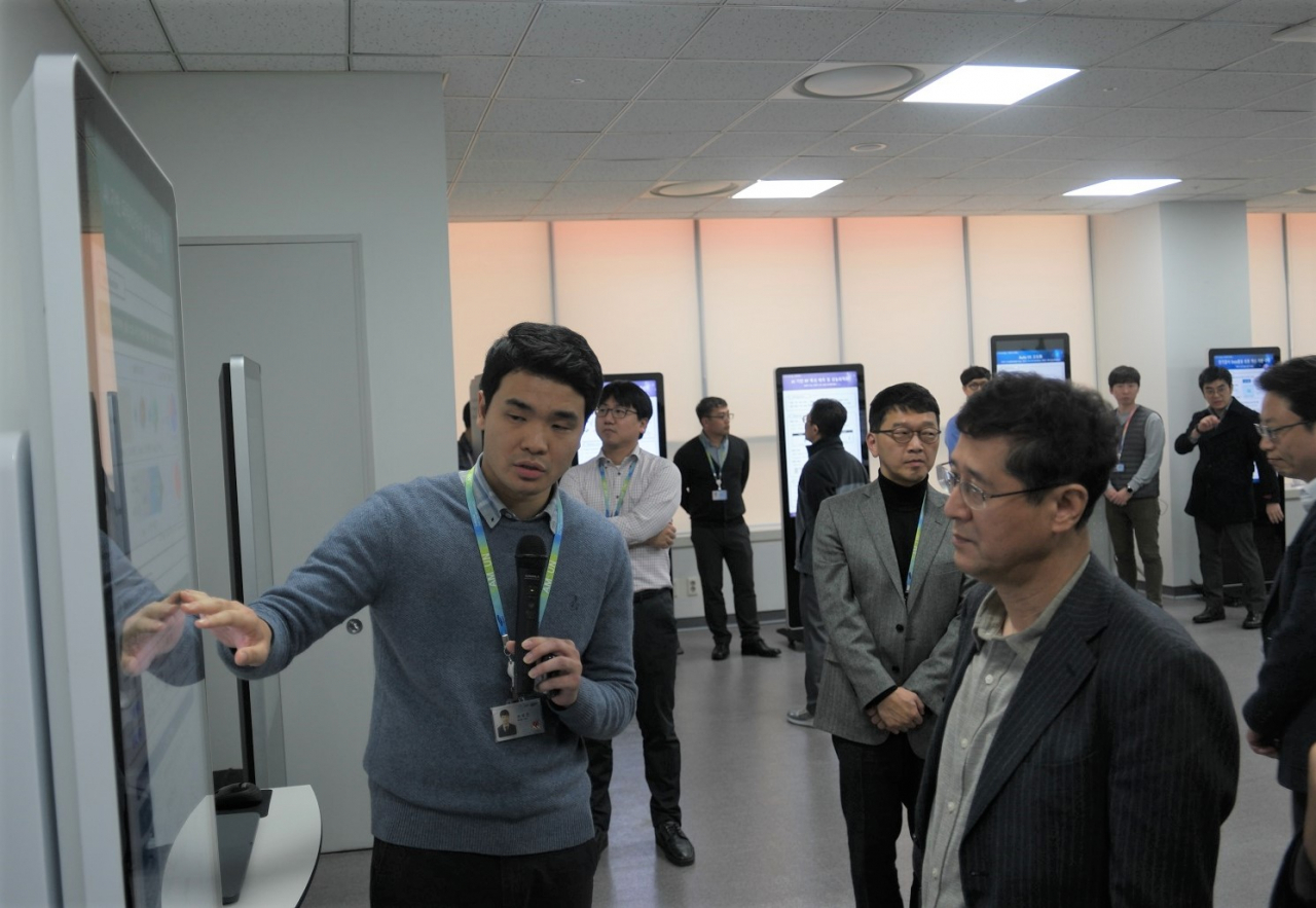 삼성전기 대표이사 이윤태 사장이 AI 통합 플랫폼을 통해 과제를 수행한 사내 AI전문가로부터 설명을 듣고 있다.[삼성전기 제공]