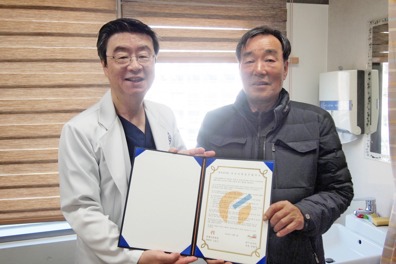 〈방우리 마을 의료지원업무 협약을 맺는 고용곤 병원장(右)과 마을대표 설광석 이장(左)〉