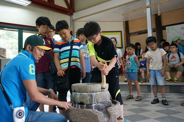 광주콩종합센터에서 맷돌갈기 체험 중인 초등학생들. [사진=광주 남구청]
