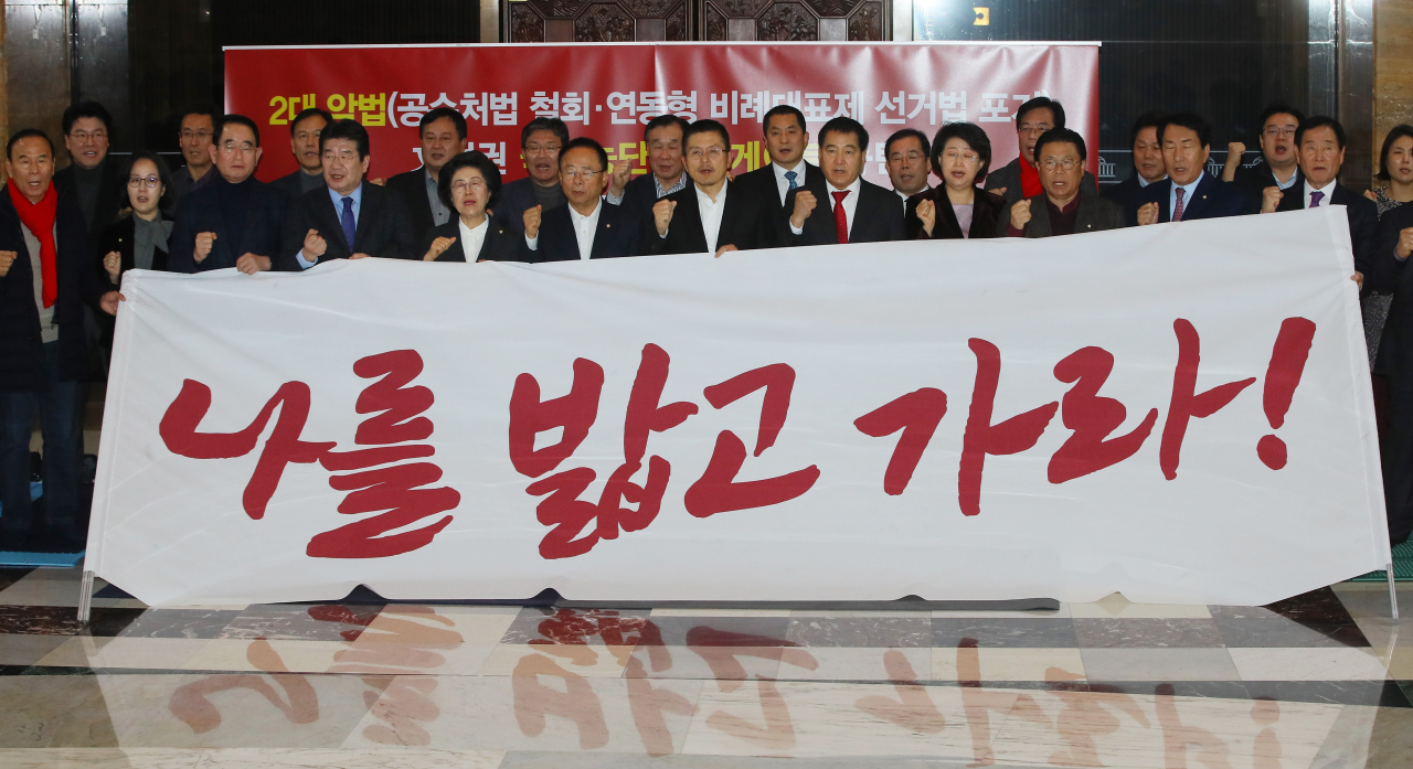 선거제 개정안과 검찰개혁법안의 패스트트랙 처리에 반대하는 황교안 자유한국당 대표, 심재철 원내대표 등 의원들이 12일 국회 로텐더홀 농성장에서 현수막을 들고 있다. [연합]