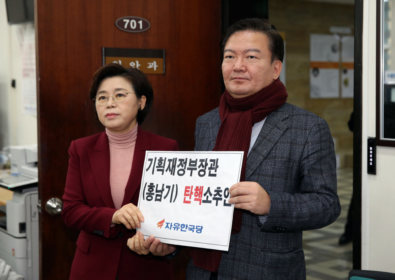 자유한국당 김정재 원내대변인, 민경욱 원내부대표가 12일 국회 의안과에 '홍남기 기획재정부장관 탄핵소추안'을 제출하고 있다. [연합]