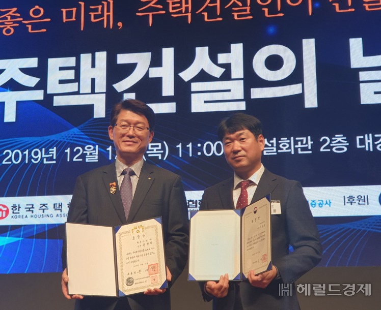 화성산업 권진혁 상무(왼쪽)와 신일용 부장이 대통령 표창과 국토부 장관 표창을 받은 뒤 기념촬영을 하고 있다.[화성산업 제공]