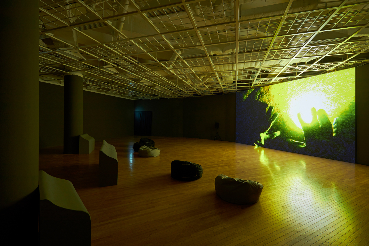 Visitors watch Kim Hee-cheon’s “Deep in the Forking Tanks” in a dark room at Art Sonje Center in Samcheong-dong, Seoul. (Art Sonje Center)
