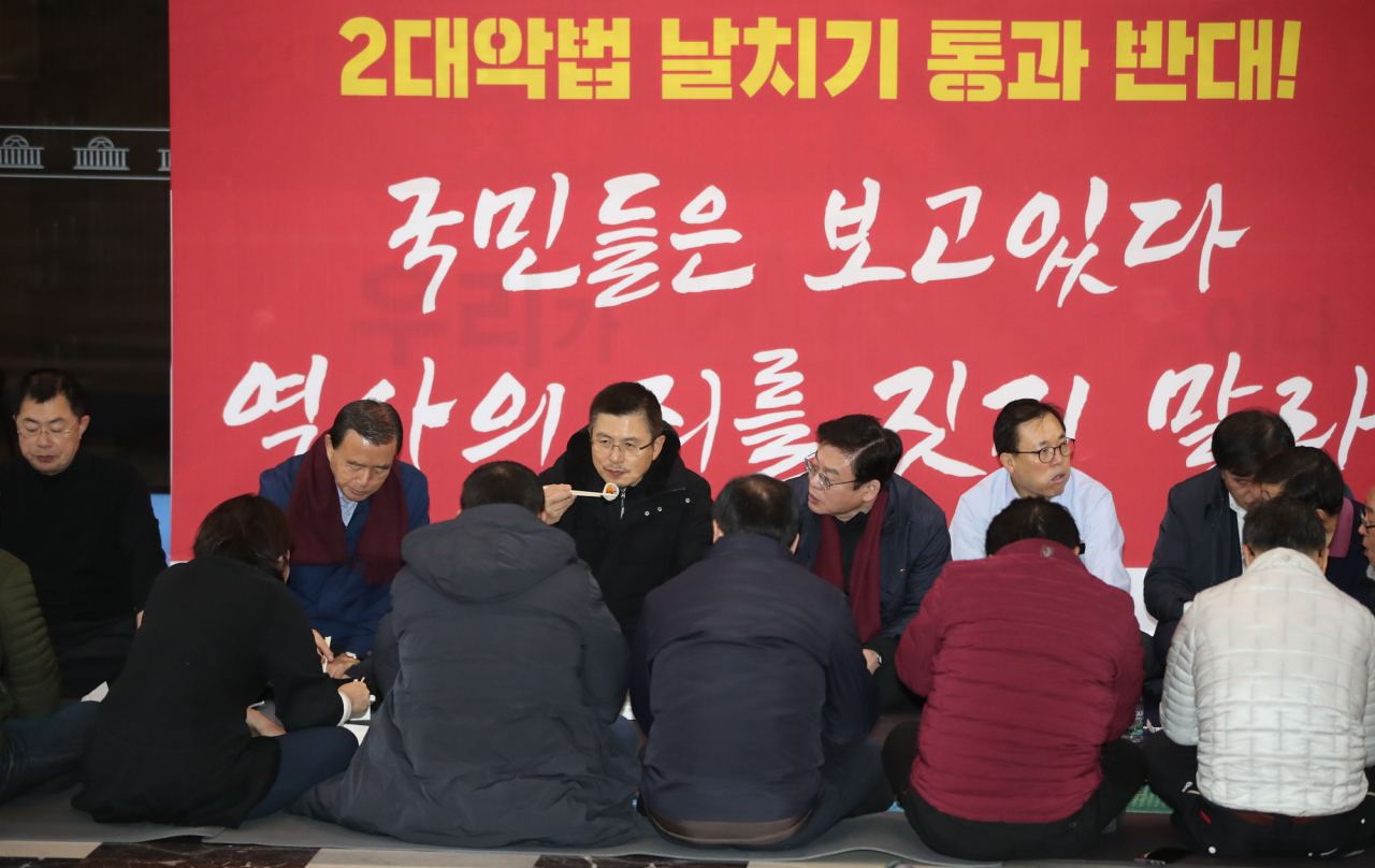 선거법과 검찰개혁법 등 패스트트랙(신속처리안건) 법안 저지를 위해 서울 여의도 국회 로텐더홀에서 밤샘 농성을 진행 중인 자유한국당 황교안 대표가 16일 오전 동료 의원들과 김밥 등으로 아침 식사를 하며 대책을 논의하고 있다. [연합]