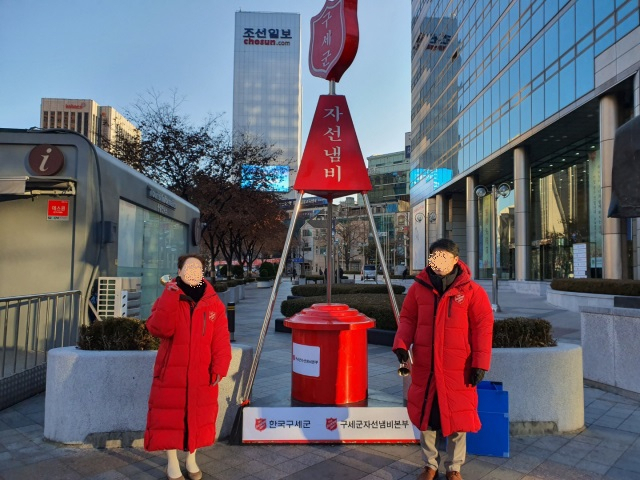 지난 12일 오후 서울 종로구 지하철 5호선 광화문역 앞에서 만난 구세군 자선냄비 모금 자원봉사자 이모(46) 씨 부부. [정세희 기자]