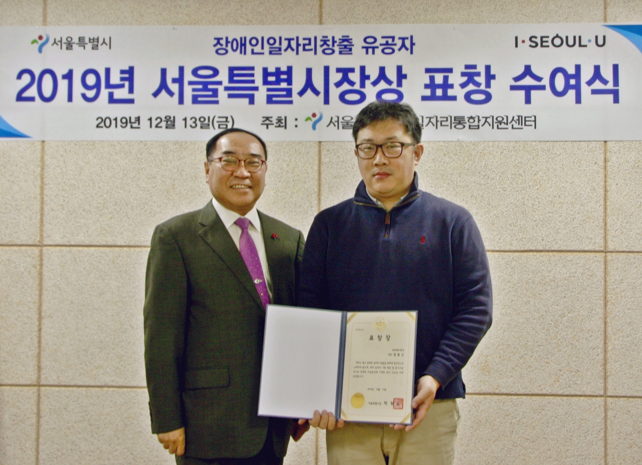 지난 13일 서울시 강남구 서울시립장애인행복플러스센터에서 열린 장애인 일자리창출 유공자 표창 수여식에서 티웨이항공이 2019년 장애인 우수고용 사업체로 선정됨돼 서울특별시장 표창을 수상했다. 왼쪽부터 김영배 서울시장애인일자리통합지원센터 원장, 설재인 티웨이항공 인사노무 팀장. [티웨이항공 제공]​