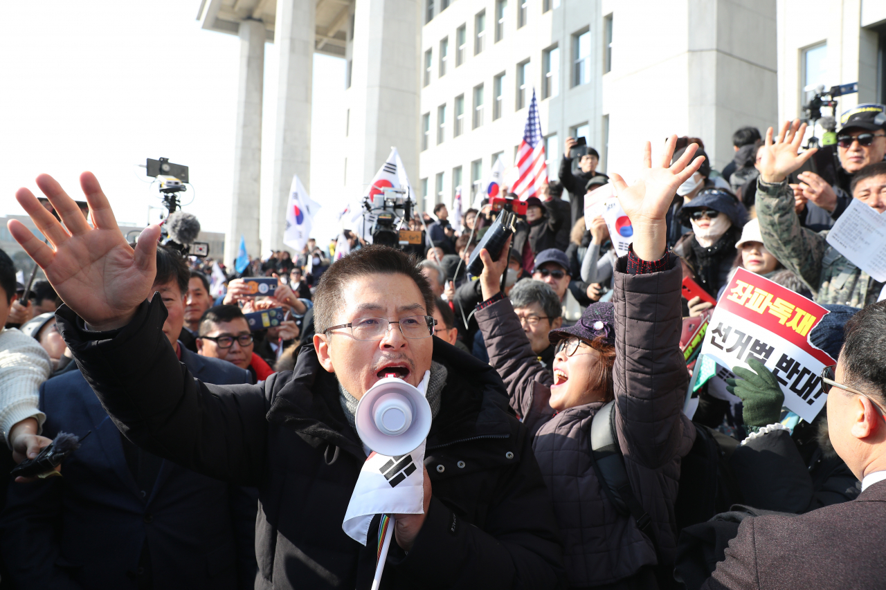 황교안 자유한국당 대표가 16일 서울 여의도 국회에서 열린 '공수처법 선거법 날치기 저지 규탄대회' 참가자들과 함께 시위를 벌이고 있다. 이들은 본청 무단 진입을 시도하다 경찰에 막혀 입구에서 집회를 열었다. [연합]