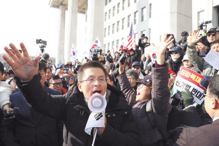 황교안 자유한국당 대표가 16일 서울 여의도 국회에서 열린 ‘공수처법 선거법 날치기 저지 규탄대회’ 참가자들과 함께 시위를 벌이고 있다. 이들은 본청 무단 진입을 시도하다 경찰에 막혀 입구에서 집회를 열었다. [연합]