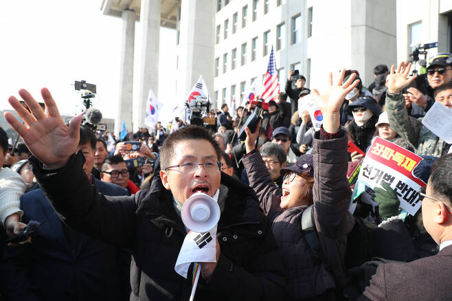 2019년 12월 16일 오전 11시 국회 본청 계단 앞에서 열린 공수처법 선거법 날치기 규탄대회에 참가한 참가자들이 국회 본청 입구 앞을 막아선 경찰들과 대치하고 있다. 경찰과 한국당 측은 이날 집회 참가자들을 약 2000여 명으로 추산했다. [연합]