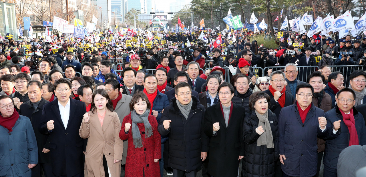 자유한국당 황교안 대표와 의원들이 18일 여의도 국회 정문 인근에서 열린 '공수처법·선거법 날치기 저지 규탄대회'에서 지지자들과 함께 구호를 외치고 있다. [연합]