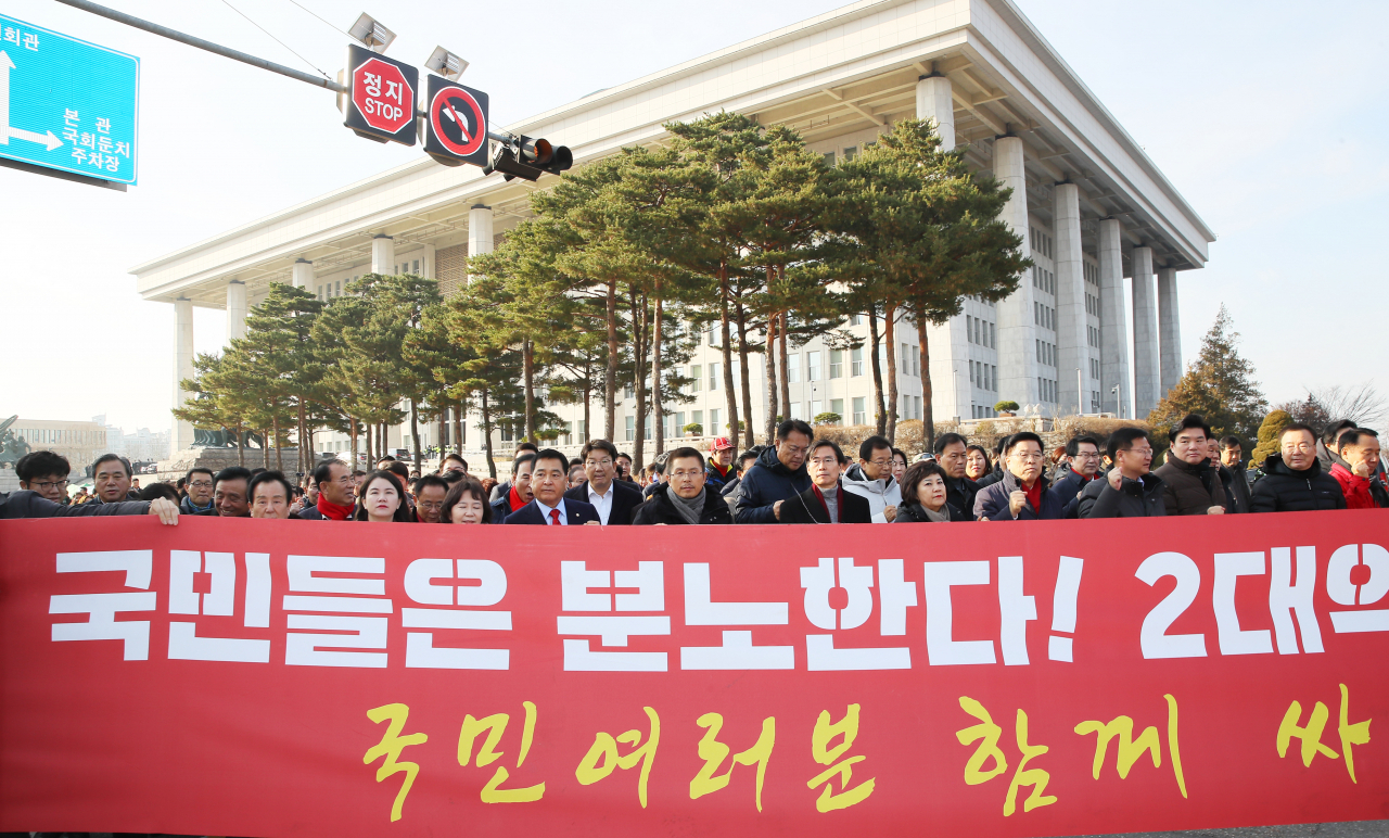 자유한국당 황교안 대표, 심재철 원내대표 등 의원들이 18일 국회 본관 앞에서 열린 '공수처법·선거법 날치기 저지 규탄대회'를 마치고 국회 밖으로 향하며 구호를 외치고 있다. [연합]