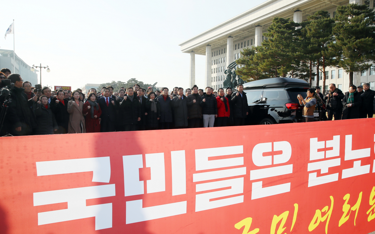 자유한국당 황교안 대표, 심재철 원내대표 등 의원들이 18일 국회 본관 앞에서 열린 '공수처법·선거법 날치기 저지 규탄대회'를 마치고 국회 밖으로 향하며 구호를 외치고 있다. [연합]