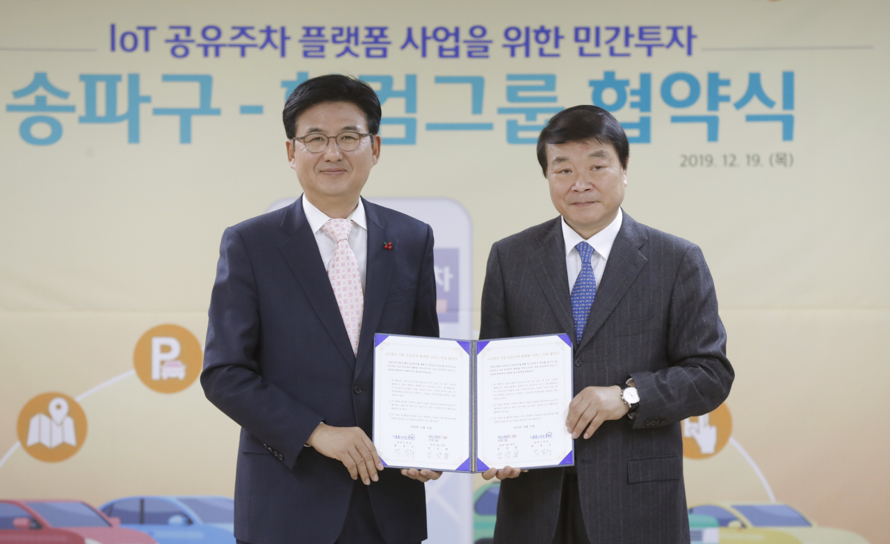 박성수(왼쪽) 송파구청장이 19일 한컴그룹과 사물인터넷 공유주차 플랫폼 사업 협약을 맺은 뒤 협약서를 들어 보이고 있다. [송파구 제공]