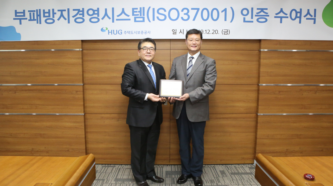 김태복 HUG 부사장(오른쪽)과 이원기 한국컴플라이언스인증원 원장이 20일 부패방지경영시스템 인증 수여식을 갖고 기념촬영을 하고 있다. [사진=HUG 제공]
