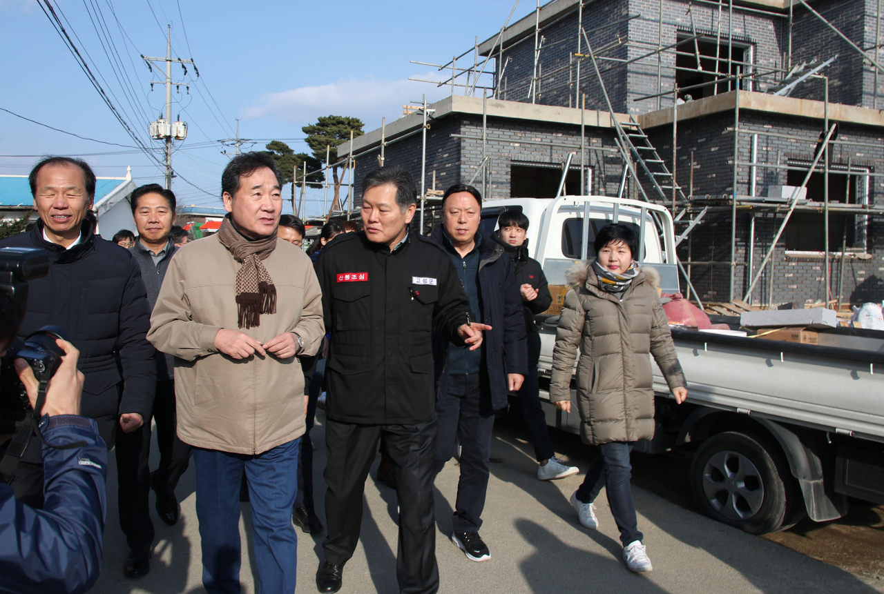 이낙연(앞줄 가운데) 국무총리가 휴일인 21일 강원도 고성군 토성면 용촌1리 산불 피해복구 현장을 방문해 점검하고 있다. 연합뉴스
