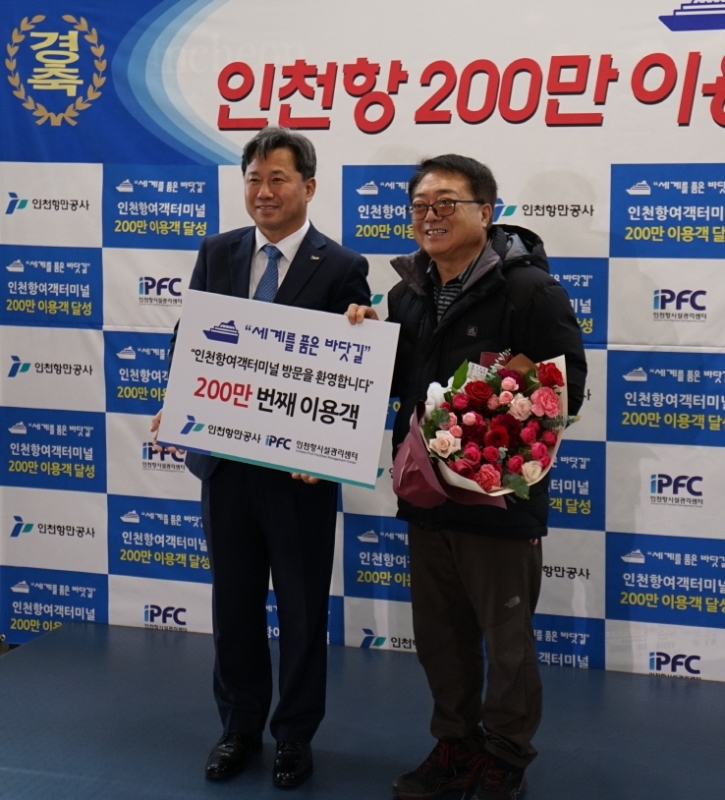 홍경선〈사진 왼쪽〉 인천항만공사 사장 직무대행이 올해 인천항 200만번째 여객 손갑용(66) 씨에게 축하 기념품을 전달하고 있다.