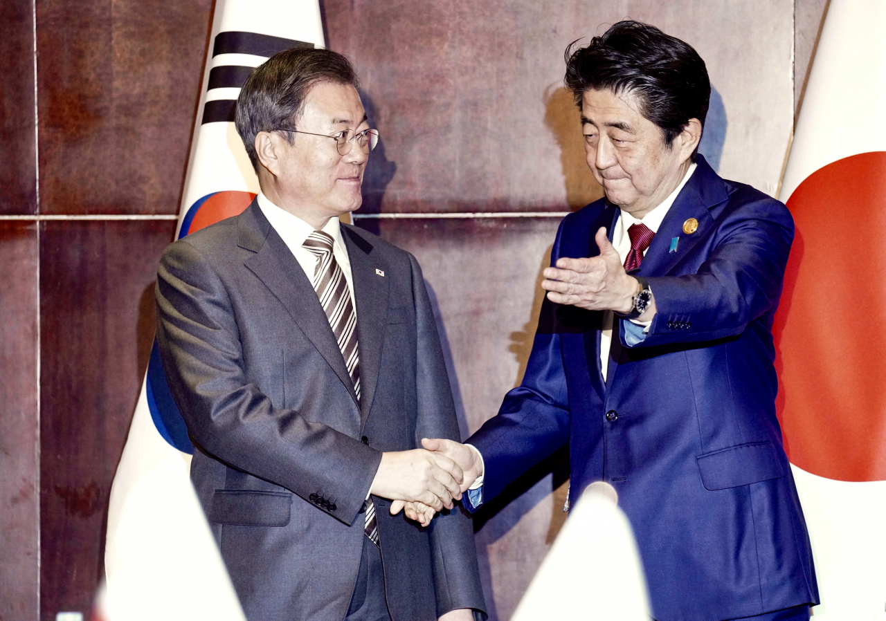 문재인 대통령과 아베 일본 총리가 24일(현지시간) 중국 쓰촨성 청두 세기성 샹그릴라호텔에서 악수하며 인사를 나누고 있다. [연합]