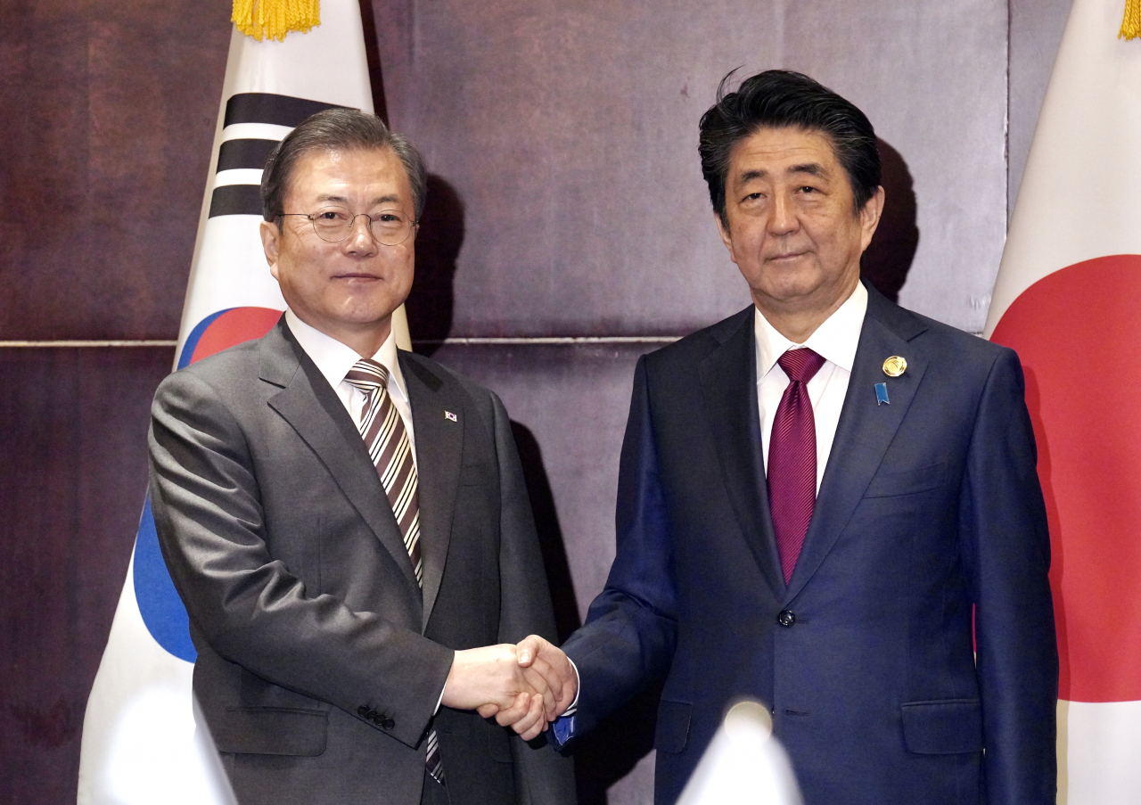 문재인 대통령과 아베 일본 총리가 24일(현지시간) 중국 쓰촨성 청두 세기성 샹그릴라호텔에서 악수하고 있다. 연합뉴스