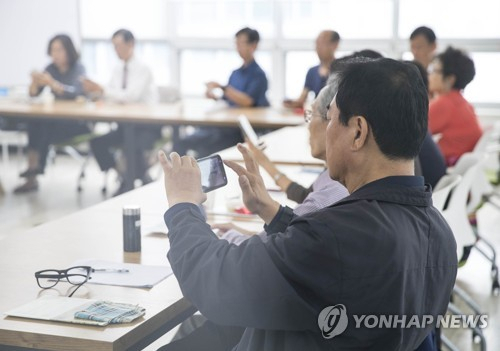 50플러스 세대가 스마트폰 활용 교육을 받고 있는 모습. [연합]