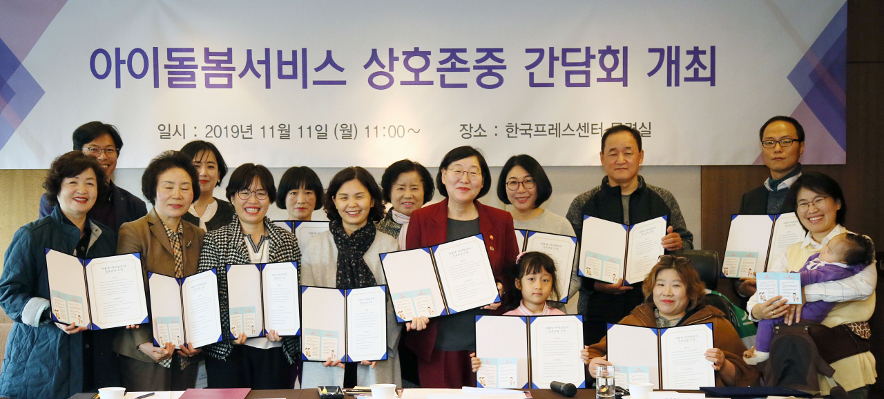 이정옥 여성가족부 장관(앞줄 왼쪽 다섯번째)이 지난 달 11일 서울 중구 한국프레스센터에서 열린 '아이돌봄서비스 상호존중 간담회'에서 이용가정의 부모와 자녀, 아이돌보미와 기념촬영을 하고 있는 모습. [여성가족부]