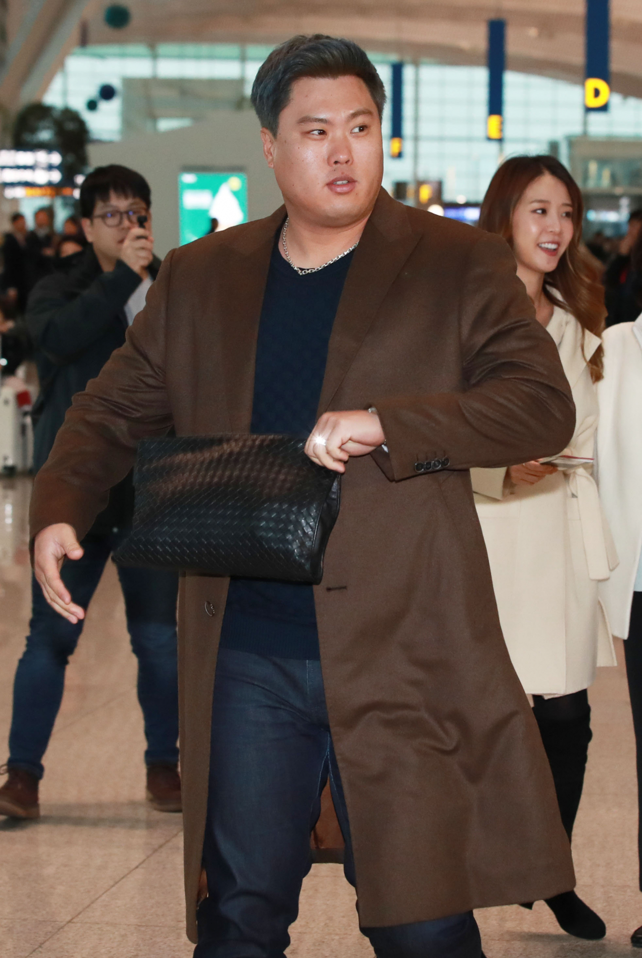 류현진이 25일 오전 인천국제공항 2터미널에서 캐나다 토론토로 출국하고 있다. 자유계약선수(FA) 신분인 류현진은 23일 토론토 블루제이스와 4년 8천만달러(약 929억4천만원)에 입단하기로 합의했다. 류현진은 메디컬테스트를 받고, 이상이 발견되지 않으면 현지에서 입단 기자회견도 소화할 계획이다. 뒤는 류현진의 아내 배지현 씨. [연합]
