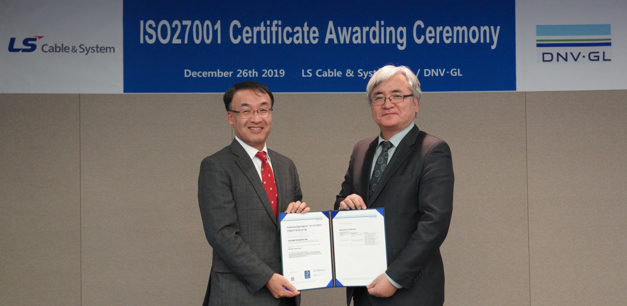 LS전선의 ISO27001 인증서 수여식이 26일 경기도 안양시 LS타워에서 열렸다. 주완섭 LS전선 경영지원본부장(왼쪽)과 DNV GL Korea의 이장섭 대표 등이 참석한 가운데 진행됐다. [LS전선 제공]