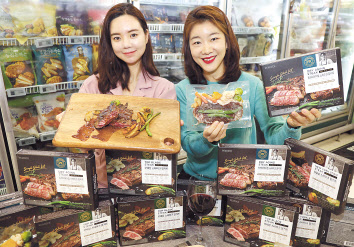 이마트 용산점 냉동냉장 코너에서 모델들이 새로나온 피코크 냉동 밀키트 스테이크를 소개하고 있다. [이마트 제공]